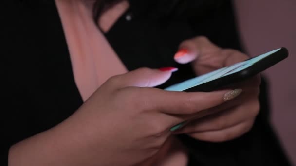 サイドビュー ネイルポリッシュ自宅のリビングルームでスマートフォンを使用して女の子の手 メッセージを入力します 若い女性の爪磨き指のクローズアップ — ストック動画