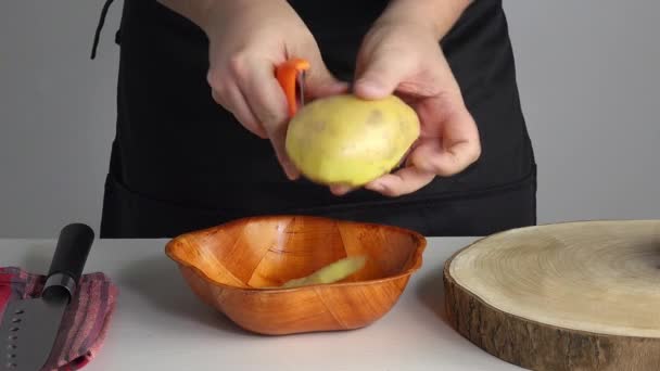 Homem Descascando Uma Batata Fresca Usando Descascador — Vídeo de Stock