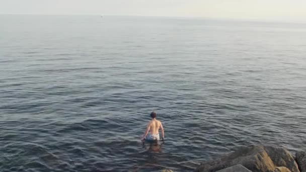 昼間の波状の海に立つ男の4K映像 — ストック動画
