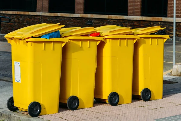 A row of new yellow waste containers on the street