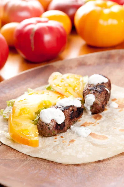 ground lamb on handmade tortilla flatbreads with heirloom tomato and tzatziki