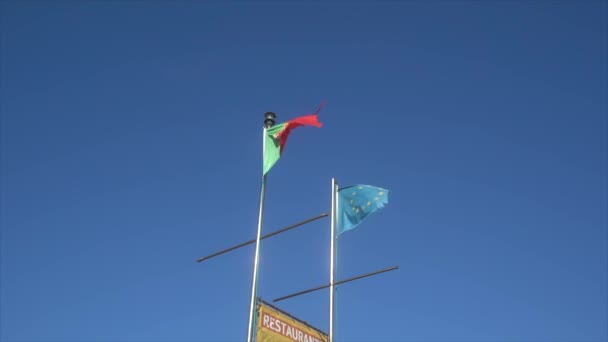 風と青空のポルトガル国旗の波の水平ビデオ 4Kでの国の誇り高き愛国者 — ストック動画