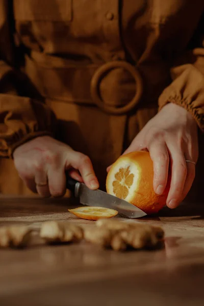 切断板にオレンジを切る者の縦射 — ストック写真