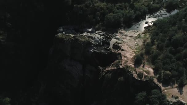 一个4K的空中拍摄的一个巨大的陡峭的高山悬崖与楼梯通往黑暗的山底 — 图库视频影像