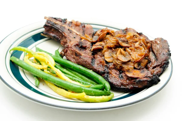 rib steak with sauteed mushrooms and onions, and vegetables