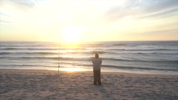 ビーチで美しい夕日を楽しむフィッシャーマンの4K水平ワイドショット — ストック動画