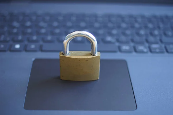 A closeup shot of a metal locked padlock on a laptop