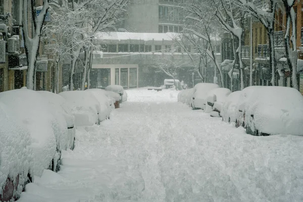 街道上令人毛骨悚然的景象 还有停在大楼附近被大雪覆盖的汽车 — 图库照片