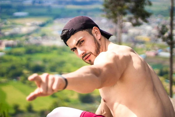 Deportista Guapo Masculino Mostrando Algo Con Una Mano Mientras Descansa — Foto de Stock