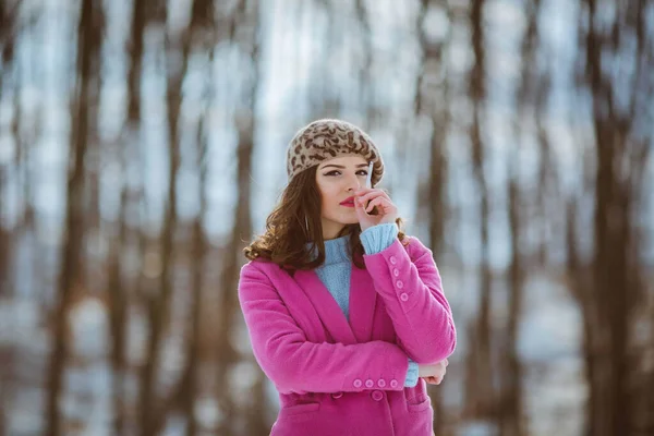 ヒョウ柄のベレー帽をかぶったスタイリッシュな女性と屋外でタバコを吸うピンクのコート — ストック写真