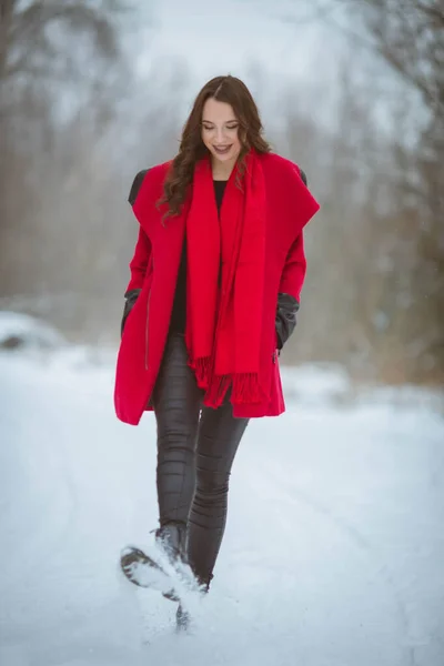 冬の日にカメラのためにポーズをとる赤いコートの魅力的な幸せなボスニアの女性 — ストック写真