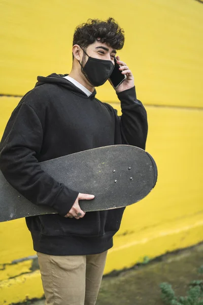 Egy Fiatal Európai Férfi Korcsolyával Vidáman Telefonál — Stock Fotó