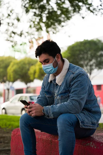 Vedere Laterală Unui Tânăr Chipeș Mască Față Medicală Tastând Telefon — Fotografie, imagine de stoc