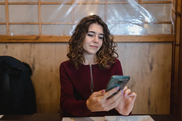 Una Joven Mujer Positiva Restaurante Mirando Teléfono Desplazándose Con Una — Foto de Stock