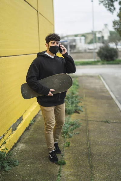 Egy Fiatal Európai Férfi Korcsolyával Vidáman Telefonál — Stock Fotó