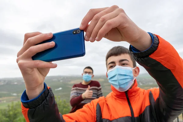 Στοκ Φωτογραφία Του Χαρούμενα Νεαρά Αγόρια Φορώντας Μάσκα Προσώπου Λόγω — Φωτογραφία Αρχείου