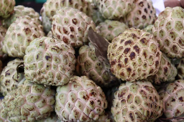 A pile of ripe sugar-apple fruits on a shop for sale