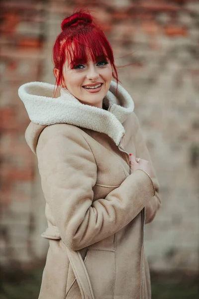 暖かい茶色の冬のコートを着た前髪のある美しい笑顔の赤い髪の女性の肖像画 — ストック写真