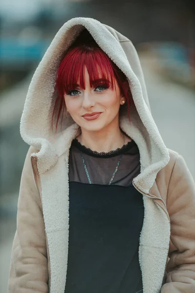 黒の衣装に暖かい冬のコートを着てカメラを見て前髪のある笑顔の若い赤髪の女の子の肖像画 — ストック写真