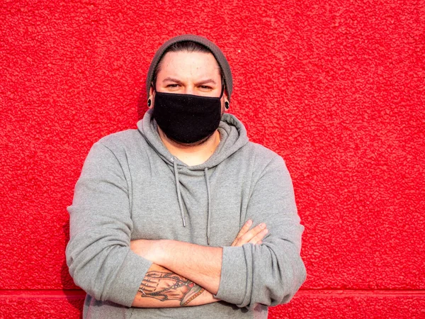Kollarını Kırmızı Bir Duvarın Önünde Kavuşturmuş Maske Takmış Spanyol Bir — Stok fotoğraf