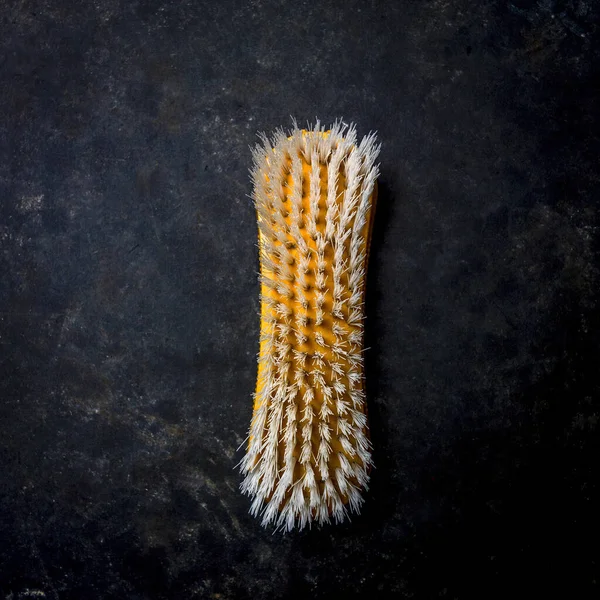 A top view of a scrubbing brush on a black surface