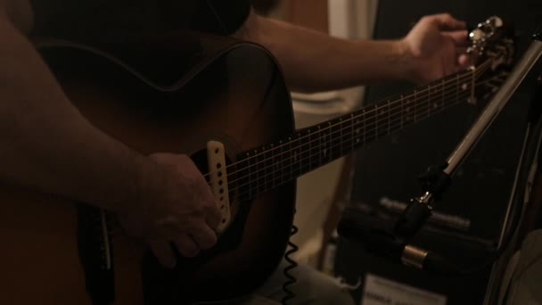 스튜디오에서 촬영의 리허설중 어쿠스틱 기타를 조율하는 사람의 움직임 — 비디오