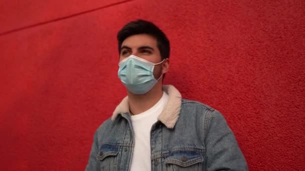 Spanish Caucasian Man Wearing Facemask Standing Front Red Wall Checking — Vídeo de stock