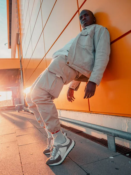 Fashionable Black Spanish Male Posing While Leaning Orange Wall — Stock Photo, Image