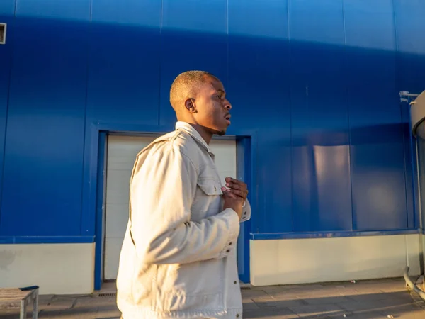 ファッショナブルな黒スペインの男性は青い壁に対してポーズ — ストック写真