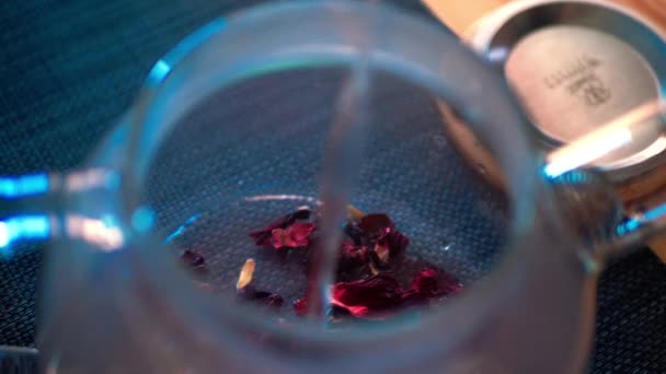 Een Hand Vullen Warm Water Theepot Met Droge Aromatische Bloemblaadjes — Stockvideo