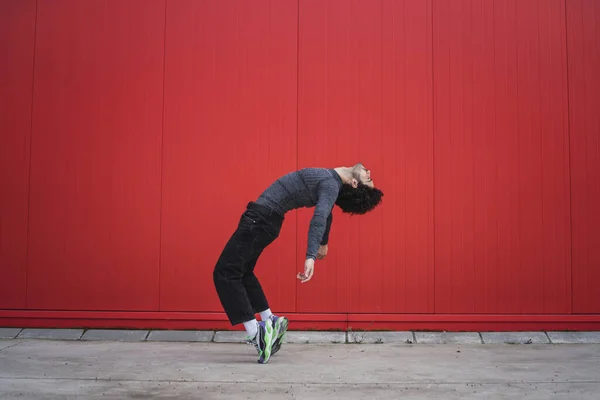 Młody Elastyczny Mężczyzna Stojący Głęboko Wygiętymi Plecami Tyłu Czerwona Ściana — Zdjęcie stockowe
