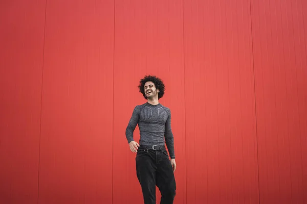 Een Vrolijke Stijlvolle Spaanse Man Met Krullend Haar Poseren Rode — Stockfoto