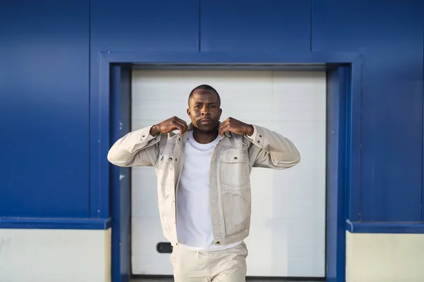 青と白の壁の前に屋外に立っている若い黒人男性のクローズアップショット — ストック写真