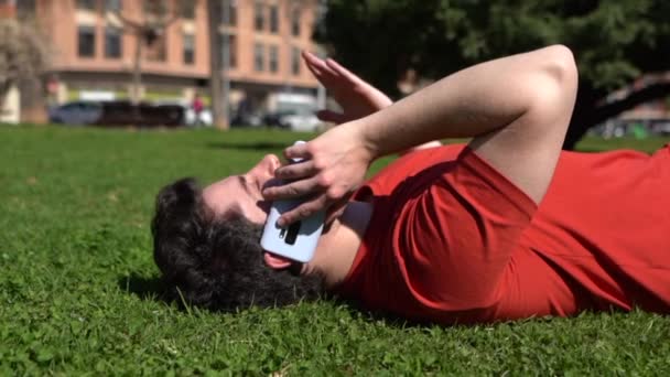 Młody Hiszpan Rozmawiający Przez Telefon Wyjaśniający Coś Poruszając Ręką Leżącą — Wideo stockowe