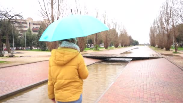Slow Motion Spanish Woman Umbrella Walking Park Rain Shot — Vídeos de Stock