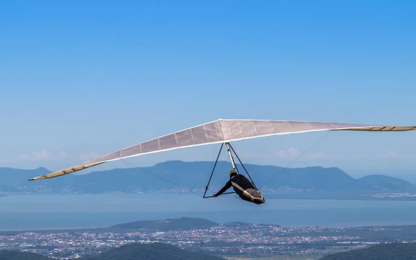 A person hang gliding over a coastal area