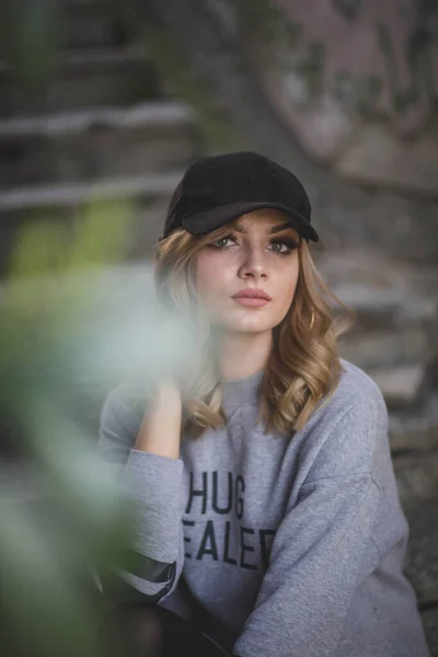 Een Aantrekkelijke Blanke Vrouw Met Een Zwarte Pet Tegen Een — Stockfoto