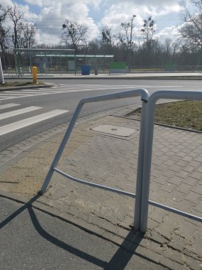 A closeup shot of a metal border  and pedestrian crosswalk in park background clipart