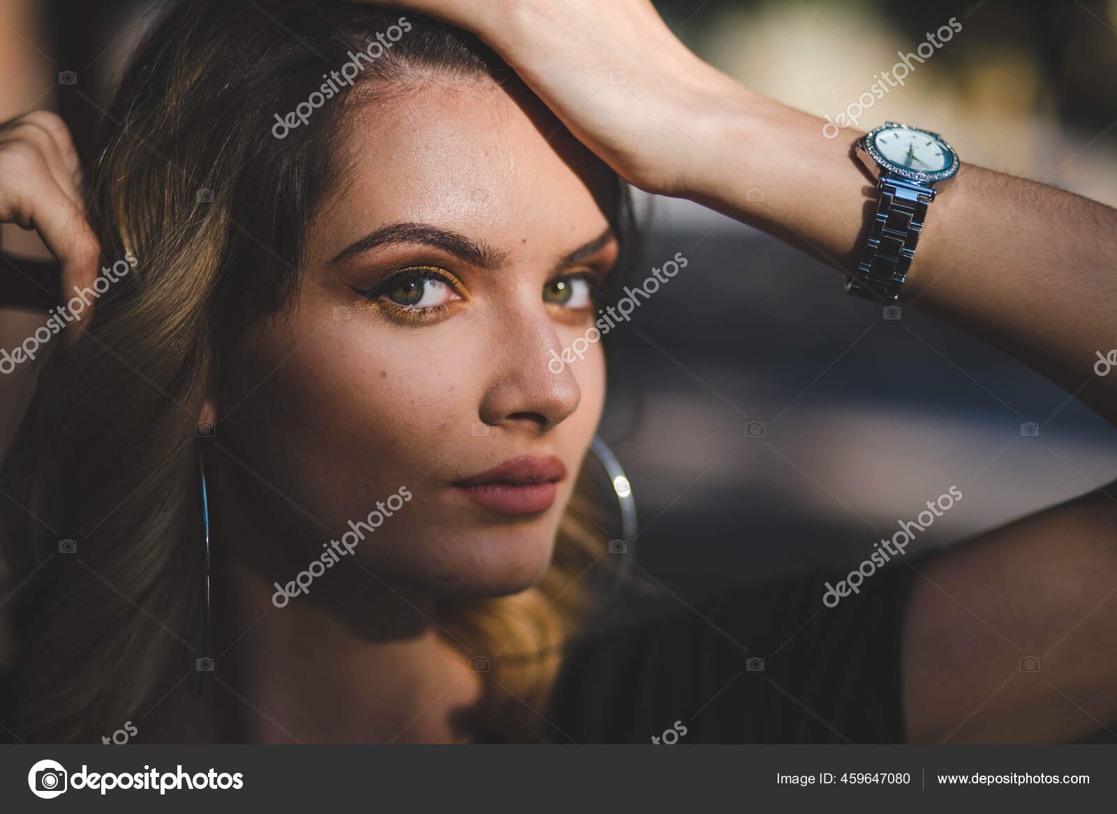 Retrato de uma jovem mulher bonita com noite maquiagem tocando seu