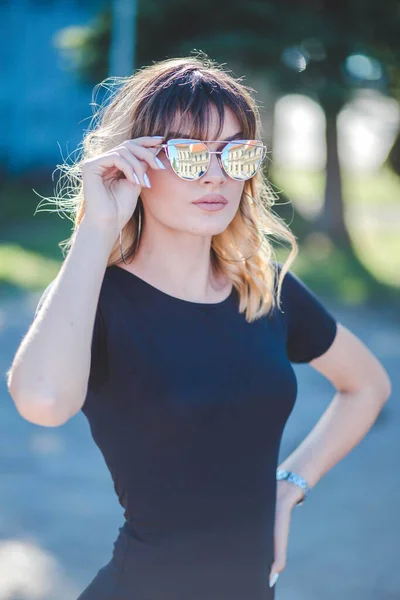 Pionowy Portret Młodej Atrakcyjnej Blondynki Pozującej Dotykając Okularów Przeciwsłonecznych — Zdjęcie stockowe