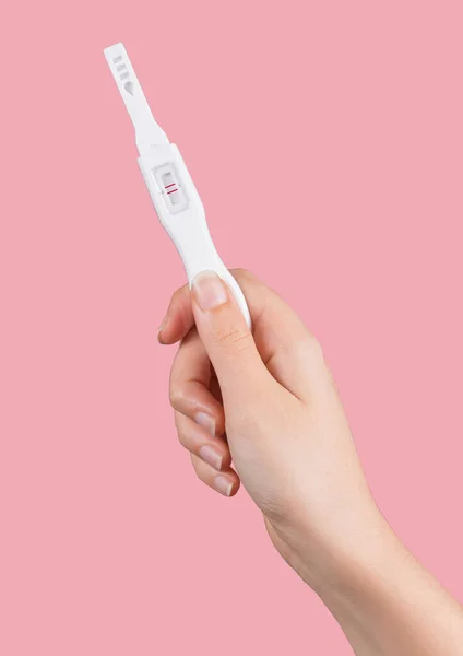 女性の手の垂直ショットが陽性の結果と妊娠検査を保持 — ストック写真