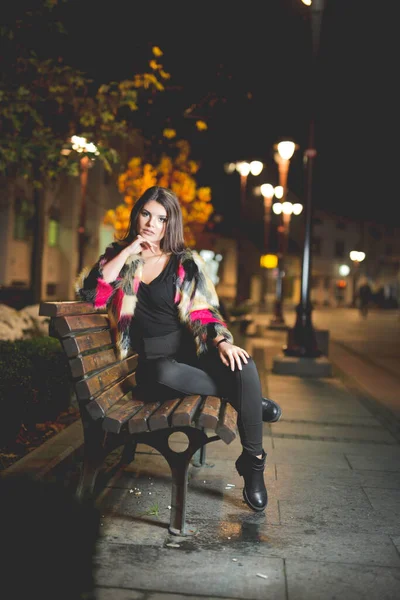 Vertical Shot Female Fashionable Jacket Posing Sitting Bench Street Night — Stockfoto