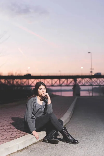 Disparo Vertical Una Joven Mujer Caucásica Sentada Una Acera Atardecer — Foto de Stock