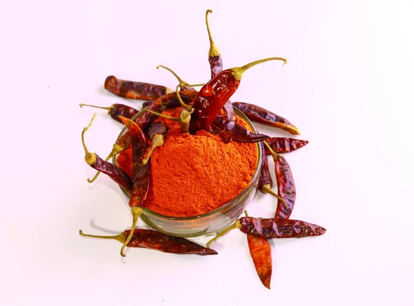 A top view dry red chilly peppers and powder of dried red chilies in a bowl in the light background
