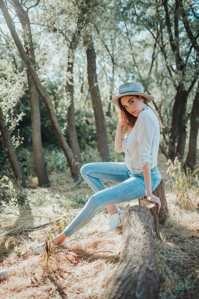 Tiro Vertical Uma Jovem Mulher Elegante Sentada Toco Árvore Uma — Fotografia de Stock