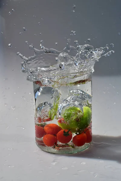 Ein Vertikaler Schuss Gemüse Der Ein Glas Fällt Verursacht Wasserspritzer — Stockfoto