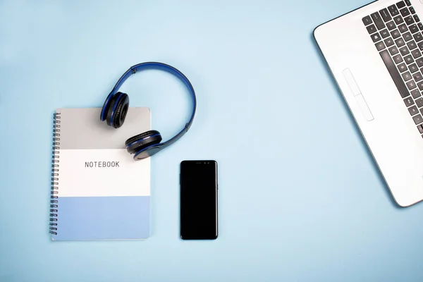 Notatnik Słuchawki Telefon Komórkowy Laptop Niebieskiej Powierzchni Przestrzenią Kopiowania — Zdjęcie stockowe