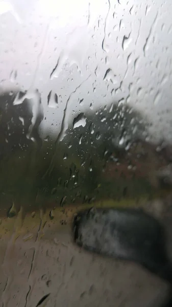 Pionowe Ujęcie Okna Samochodu Pokrytego Kropelkami Deszczu — Zdjęcie stockowe