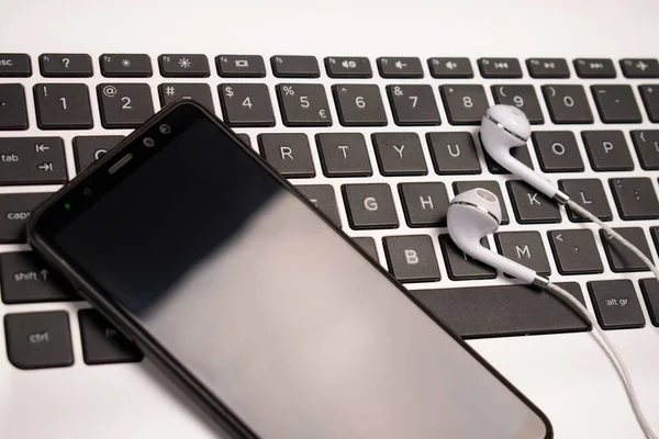 Black Smartphone White Earphones Notebook Keyboard — Stock Photo, Image