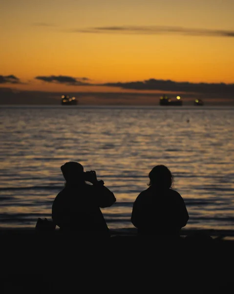 Силуэт Женщины Разговаривающей Телефону Своей Подругой Смотрящей Красивый Закат Море — стоковое фото
